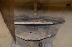 Closeup showing unfished plastering on shelves demonstrating attachment of walls to shelves