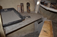 View of the previous shelf, in place and out of its mold, with a batch of dry plaster ready to add water and mix